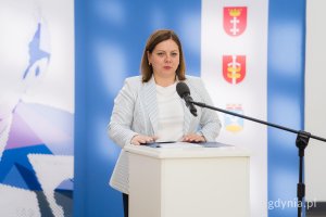Kobieta w jasnej marynarce z mikrofonem