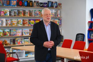 Mężczyzna stojący w sali i przemawiający do słuchaczy