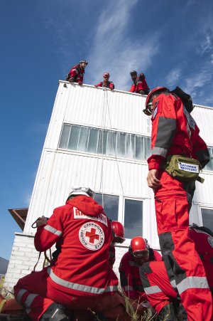 Manewry ratownicze w Porcie Gdynia. Trzech ratowników znajduje się na dachu budynku, trzech jest przed budynkiem.