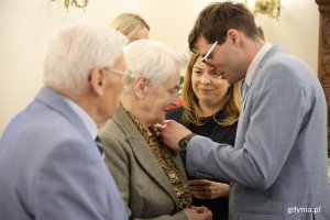 Mężczyzna w garniturze wręcza medal innemu mężczyźnie