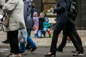 Wielobarwny Pomorski Przemarsz Seniorów ulicami Gdyni. Paradę ogląda mężczyzna z dwójką dzieci. Fot. Karol Stańczak