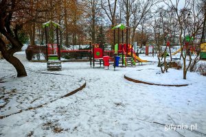 Plac zabaw i widoczny w tle budynek przedszkola