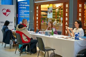 Uczestnicy akcji z okazji Dnia Mężczyzny przy stoisku medycznym na pasażu Centrum Handlowego Riviera