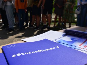 Ławka z materiałami edukacyjnymi o projekcie, w tle publicznośc wystawy