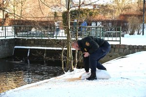Strażnik w mundurze z workiem nad brzegiem rzeki