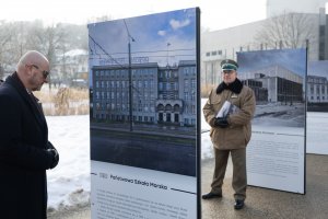 Dw&oacute;ch mężczyzn: jeden w garniturze, drugi w mundurze wojskowym oglądają wysatwę