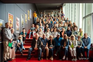 Przewodnicy Danuta Ślipy i Robert Chrzanowski wraz z osobami uczestniczącymi w spacerze Szlakiem Filmowym Gdyni zgromadzeni w Gdyńskim Centrum Filmowym