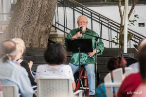 Bogusław Dornowski, współzałożyciel Czerwonych Gitar podczas koncertu towarzyszącego otwarciu nowej sceny przy plaży w Orłowie. Na pierwszym planie siedzący na krzesłach na tarasie widzowie // fot. Karol Stańczak