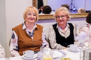 Dwie seniorki pozują do zdjęcia przy świątecznym stole 