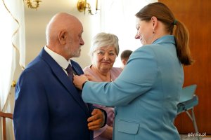 Prezydent Aleksandra Kosiorek wręcza medal jubilatom 