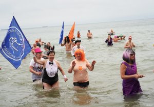 Grupa os&oacute;b w morzu w kolorowych strojach