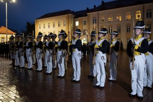 Podchorążowie w historycznych mundurach stoją na placu apelowym.