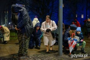 Ludzie idą ulicami miasta w czasie drogi krzyżowej.