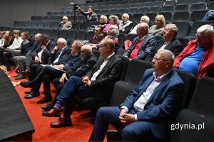 Elegancko ubrane osoby siedzące na sali kinowej