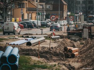 trwające roboty drogowe, widoczne elementy infrastruktury, oznakowanie, ruch uliczny