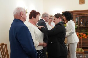 Kobieta wręcza medal innej kobiecie