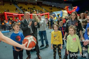 Dzieci rzucają piłką do kosza, brawo bije im mężczyzna w garniturze - prezydent miasta.