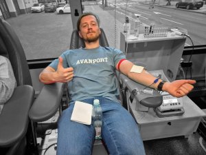 Mężczyzna w niebieskiej koszulce w trakcie oddawania krwi