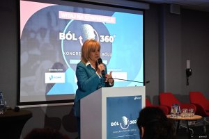 Kobieta w turkusowej marynarce na m&oacute;wnicy