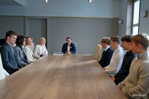 Grupa uczni&oacute;w gdyńskich szk&oacute;ł, kt&oacute;rzy uczestniczyli w rejsie z okazji stulecia miasta na &bdquo;Pogorii&rdquo; wraz z opiekunami podczas spotkania z prezydent Aleksandrą Kosiorek w Urzędzie Miasta Gdyni 