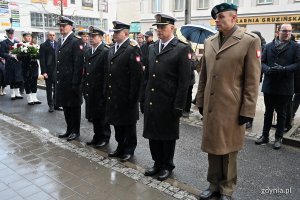 Marynarze Marynarki Wojennej i żołnierz stoją w szeregu.