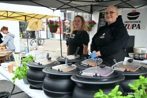 Stoisko restauracji „Przystanek zupa” na 5. edycji festiwalu „Kulinarna Świętojańska”. Na pierwszym planie naczynia z róznymi rodzajami zup. Za stołem stoją dwie uśmiechnięte restauratorki // fot. Magdalena Czernek