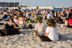 Ludzie siedzą w wiankach na plaży