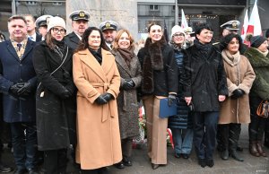 Grupa os&oacute;b pod pomnikiem