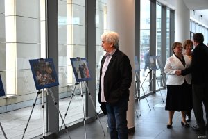 Mężczyzna z wąsem ogląda fotografie