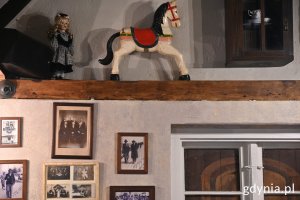 Na ścianie kawiarni stare zdjęcia, a na półce zabawki