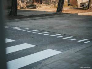 na pierwszym planie widoczne przejście dla pieszych, oznakowane poziomo