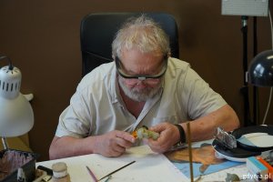 Reżyser Marek Skrobecki pochylony nad biurkiem