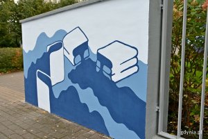 Mural z książkami, z których wylewa się woda, znajdujący się przed wejściem do Uniwersytetu WSB Merito w Gdyni