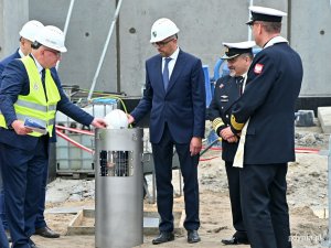 Paweł Lulewicz - prezes PGZ Stoczni Wojennej (trzeci z prawej) wkłada kask do kapsuły czasu. Obok niego stoi kmdr Piotr Skóra - szef Szefostwa Techniki Morskiej w Agencji Uzbrojenia  // fot. Magdalena Czernek