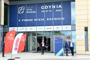 Wejście do budynku biblioteki Akademii Marynarki Wojennej. Nad nim logo i biały napis na granatowym tle: V Forum Wizja Rozwoju, Gdynia 20-21 VI 2022. Przed wejściem powiewają flagi Energi oraz Lotosu // fot. Magdalena Czernek