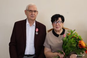 Para, mężczyzna z medalem, kobieta z bukietem kwiat&oacute;w
