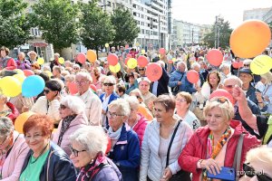 Uczestnicy przemarszu w ramach V Pomorskiego Dnia Seniora stojący na placu Kaszubskim. W rękach trzymają kolorowe balony