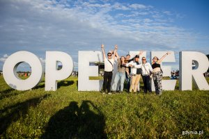 Uczestnicy festiwalu robiący zdjęcia przy znaku Open'era
