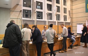 na zdjęciu ludzie rozmawiający przy biurku