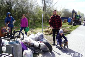 Meżczyzna w koszuli w kratkę, chłopiec z psem i stosy work&oacute;w na śmieci