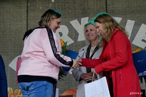 Beata Zastawna &ndash; przewodnicząca Rady Miasta Gdyni i Hanna Niedźwiecka-Pasternak &ndash; zastępca naczelnika Wydziału Ogrodnika Miasta wręczają nagrodę jednej z uczestniczek konkursu &bdquo;Gdynia w kwiatach&rdquo; 