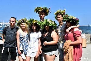 Grupa mieszkańców z kwiatowymi wiankami na głowach na bulwarze Nadmorskim // fot. Magdalena Czernek