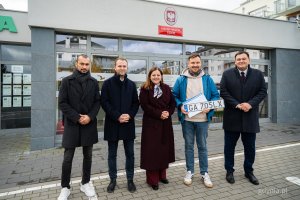 Przedstawiciele samorządu z pierwszy obsłużonym mieszkańcem przed nowo otwartym Punktem Obsługi Mieszkańców Urzędu Miasta Gdyni na Chwarznie-Wiczlinie, w lokalu przy ul. Tęczowej 37. Od lewej: radni Marcus da Silva i Norbert Anisowicz, prezydent Aleksandra Kosiorek, mieszkaniec korzystający z usługi, sekretarz miasta Łukasz Kobus (fot. Kamil Złoch)