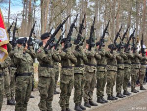 Żołnierze oddają salut bronią