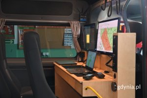 Brązowa drewniana konsola z laptopami we wnętrzu furgonu