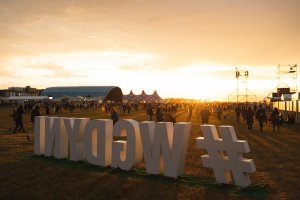 Na pierwszym planie hashtag #wGdyni. Za nim teren i uczestnicy festiwalu w promieniach zachodzącego słońca // fot. Magda Zaklika
