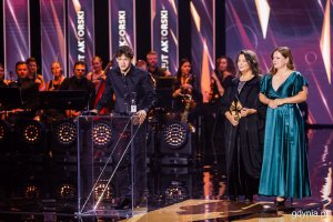 Przemawia Filip Wiłkomirski. Anna Dymna i prezydent Gdyni Aleksandra Kosiorek wręczające nagrodę za debiut aktorski. Gala wręczenia nagród 50. Festiwalu Polskich Filmów Fabularnych w Gdyni w Teatrze Muzycznym (fot. Karol Stańczak)