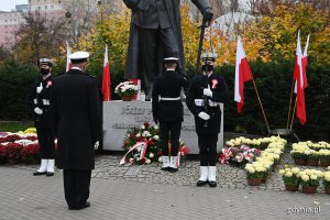 kontradm. Mirosław Jurkowlaniec - dowódca 3. Flotylli Okrętów w Gdyni składa kwiaty pod pomnikiem Józefa Piłsudskiego w Gdyni. Przy pomniku stoi posterunek honorowy złożony z dwóch żołnierzy Marynarki Wojennej. Obok pomnika powiewają biało-czerwone flagi i widać donice z chryzantemami // fot. Michał Puszczewicz