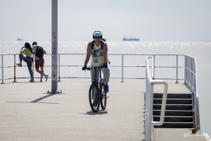 Mężczyzna jedzie na rowerze po betonowym molo.