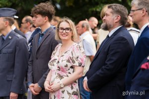 Kobieta w kolorowej sukience, mężczyźni w garniturach